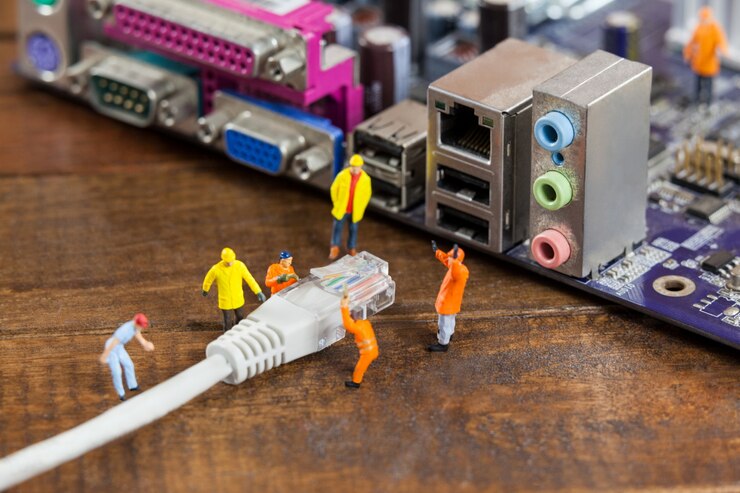Photo Gratis miniature engineer and worker plug-in lan cable to computer