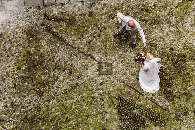 Mira desde arriba a los novios caminando por el patio trasero.