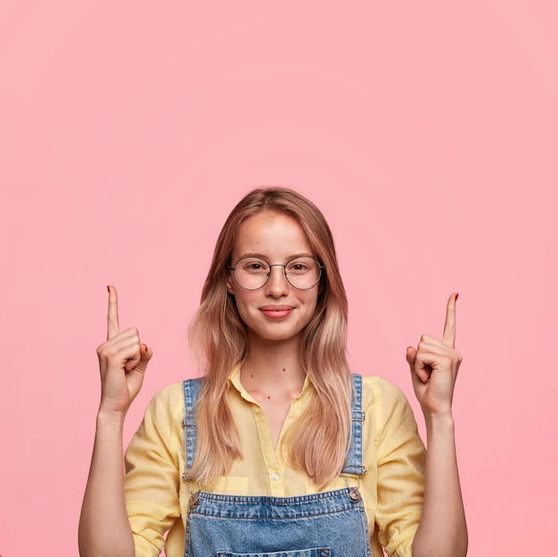 ¡Mira el techo! Encantado de modelo femenino joven con expresión complacida