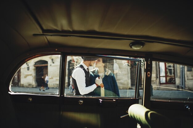 Mira a través del retro-coche a un hombre y una mujer vestidos al estilo de la vieja usanza