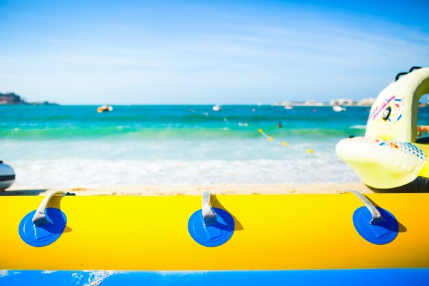 Mira por el tubo de aire azul y amarillo en las olas de espuma de mar bajo el cielo soleado