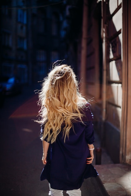 Foto gratuita mire por detrás a la mujer rubia posando en camisa azul