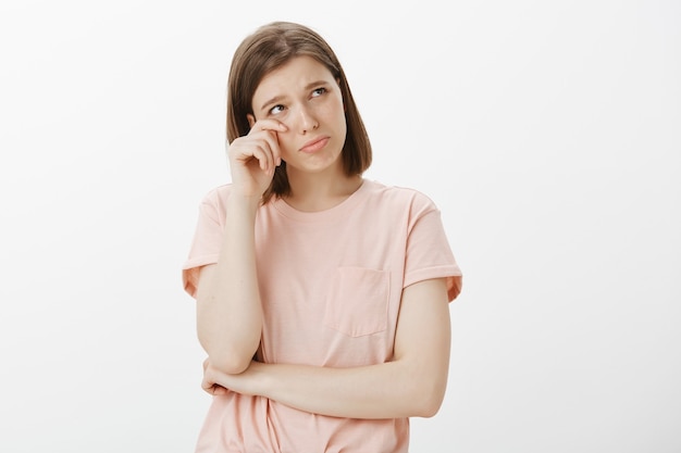 Miserable mujer insegura secándose las lágrimas y luciendo ofendida, sintiéndose triste o sola