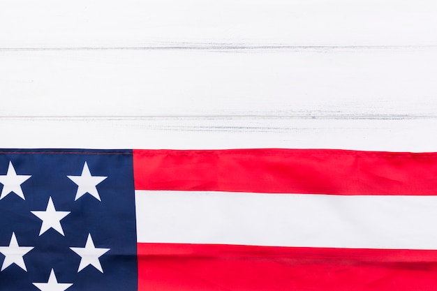 La mitad de la bandera de Estados Unidos y la mitad de la mesa de madera blanca
