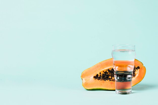 La mitad de fruta de papaya y vaso de agua