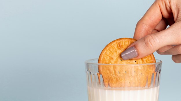 La mitad de la galleta bañada en un vaso de leche y copia el fondo del espacio