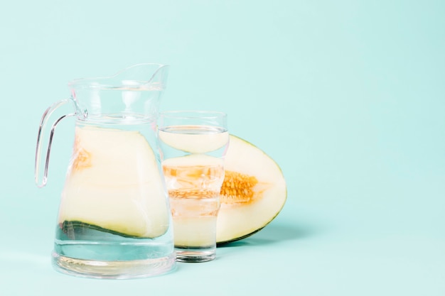 Mitad de melón con jarra llena de agua