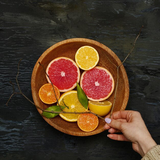 Mitades de cítricos de pomelo en placa de madera