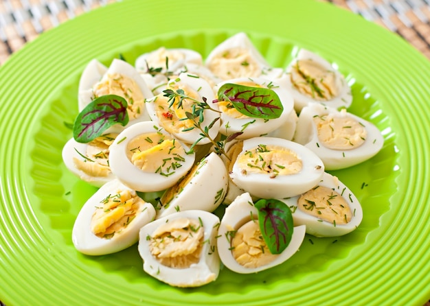 Mitades de huevos de codorniz cocidos en un plato verde