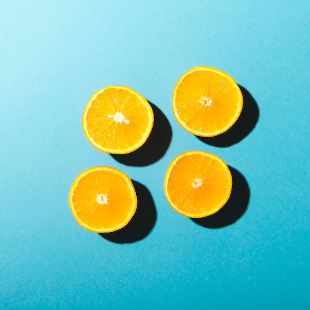 Foto gratuita mitades de naranjas sobre fondo azul