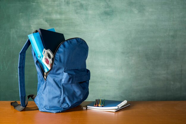 Mochila abierta con papelería y acuarelas.