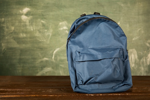 Mochila azul en mesa de madera