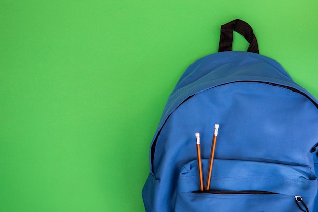Mochila escolar azul con lápices.