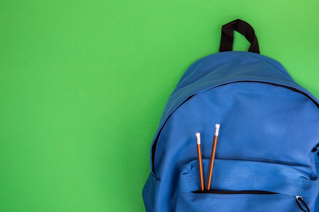 Mochila escolar azul con lápices.