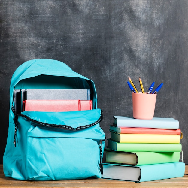 Mochila con libros y bolígrafos.