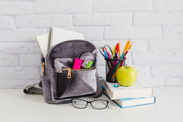 Mochila, libros, manzana y gafas