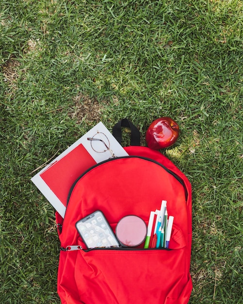 Foto gratuita mochila con útiles escolares y manzana.