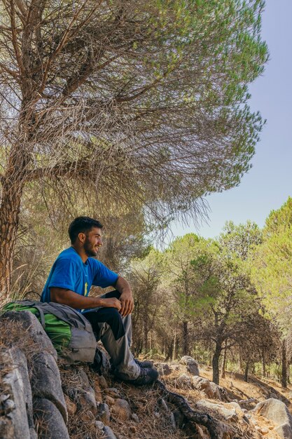 Mochilero relajando debajo de un árbol