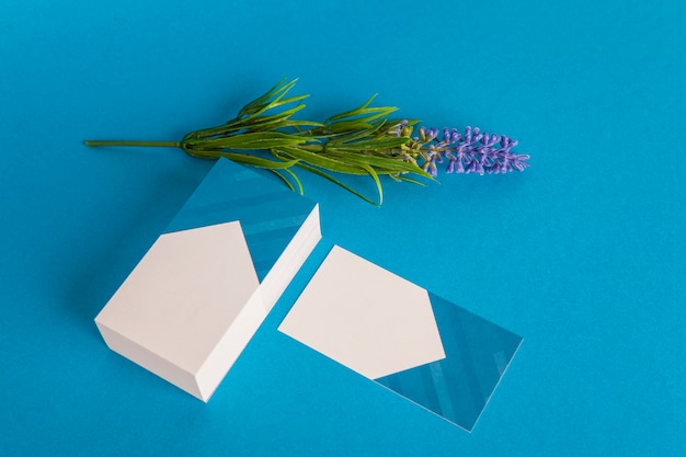 Mockup de papelería con tarjetas de visita y flor