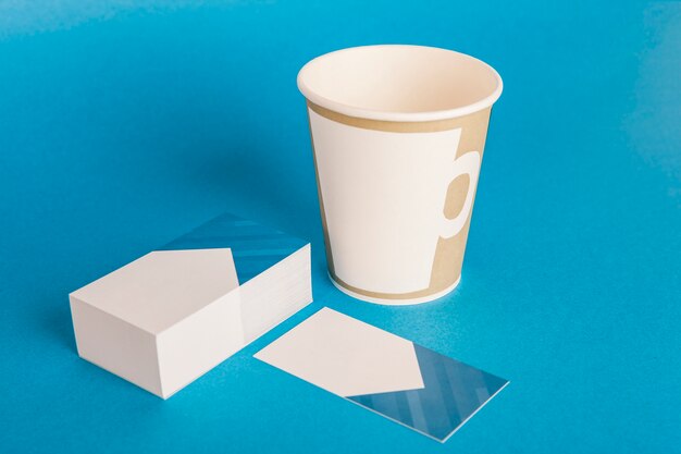 Mockup de papelería con taza y tarjetas de visita