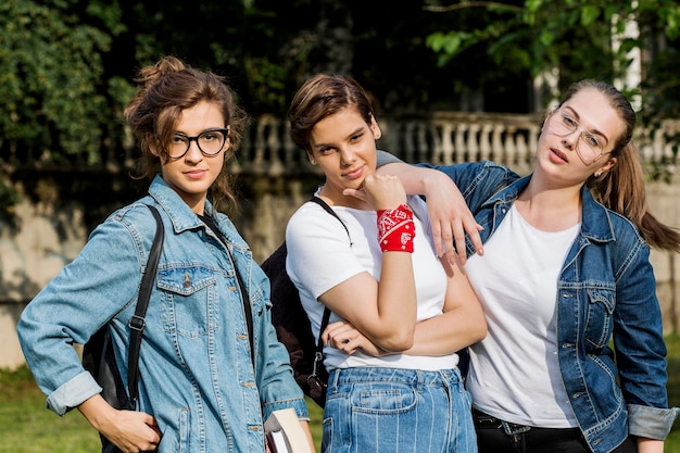 Moda amigos de pie juntos en el parque