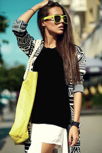 Moda elegante hermosa morena joven modelo en verano hipster ropa casual colorida posando en el fondo de la calle