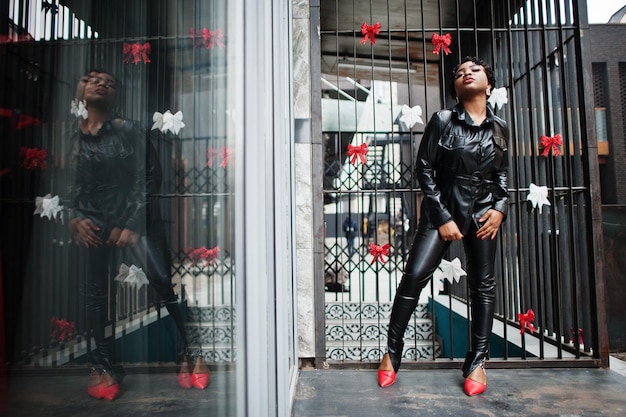 Foto gratuita moda hermosa mujer afroamericana posando en chaqueta de cuero negro y pantalones en la calle