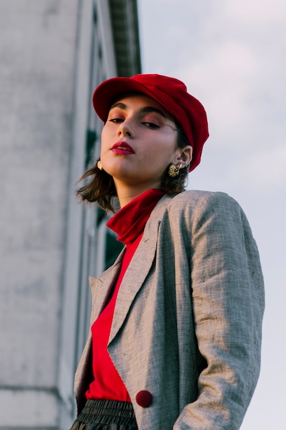 Moda joven con gorra roja mirando a cámara