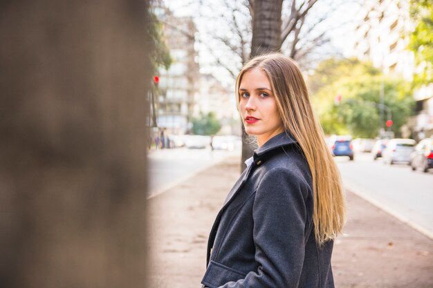 Moda joven mujer vuelta atrás y mirando a puerta cerrada