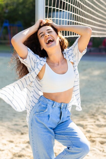 Moda joven posando junto a un campo de voleibol