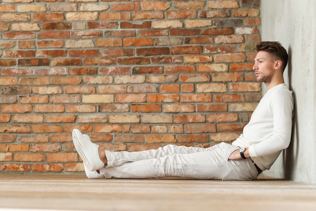 Moda masculina sobre piso de madera, joven posando