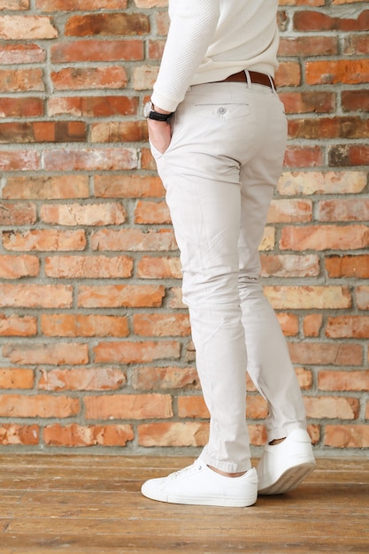 Moda masculina sobre piso de madera, joven posando