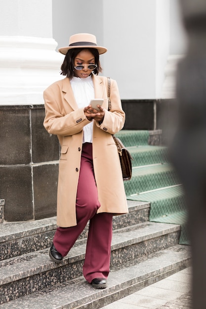 Foto gratuita moda mujer mirando su teléfono