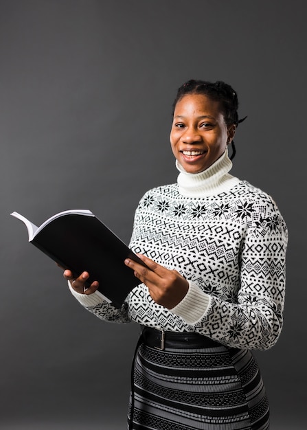 Foto gratuita modelo afroamericano sosteniendo libro tiro medio