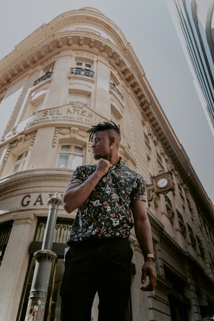 Modelo en camisa vintage posando delante de un hermoso edificio