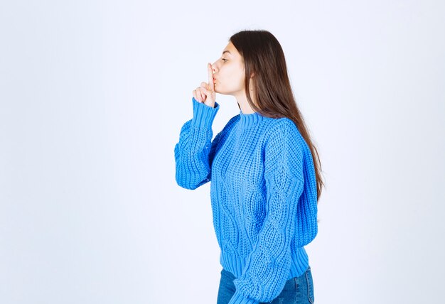 modelo de chica joven que muestra el signo de silencio.