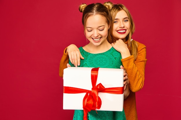 Modelo dando a su amiga una gran caja de regalo