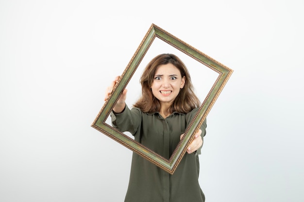 Modelo femenino adorable joven posando en medio del marco vacío. foto de alta calidad