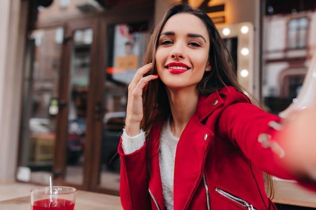 Modelo femenino blanco extático haciendo selfie en buen día