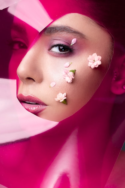 Foto gratuita modelo femenino con brillo de labios rosa y flores blancas