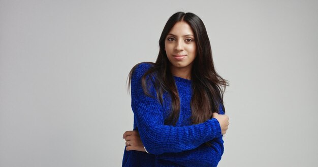 Modelo femenino latino atractivo en suéter azul brillante caliente