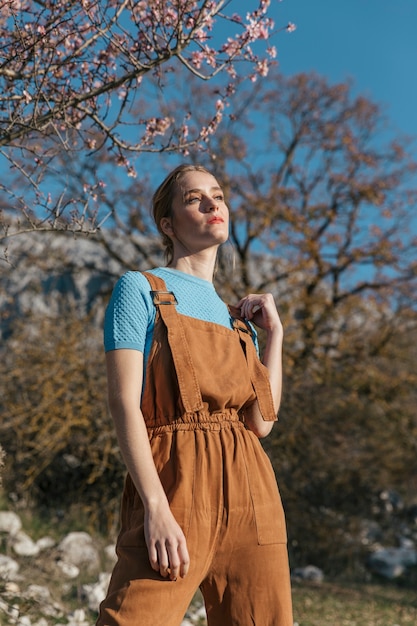 Modelo femenino posando bajo el árbol floreciente