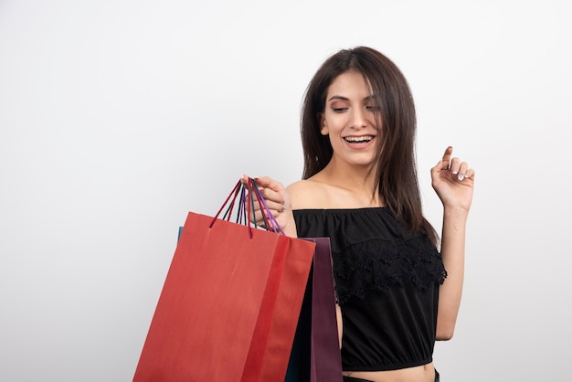 Modelo femenino posando con bolsas de la compra.