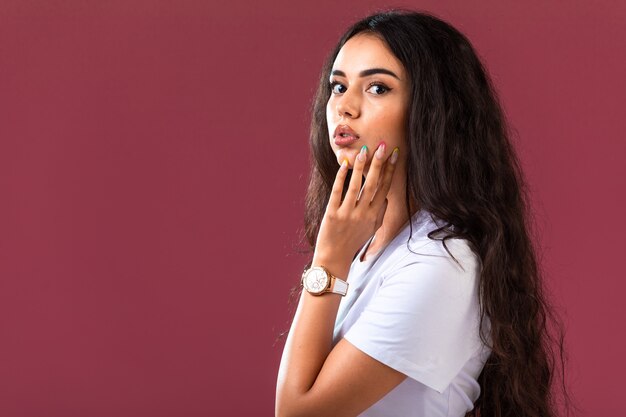 Modelo femenino posando en la pared rosa