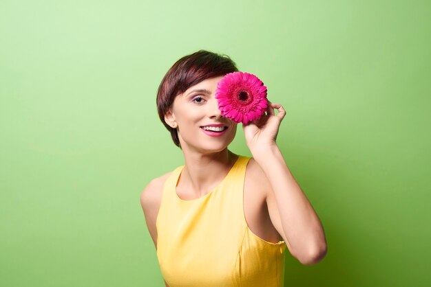 Modelo femenino que cubre el ojo con flor