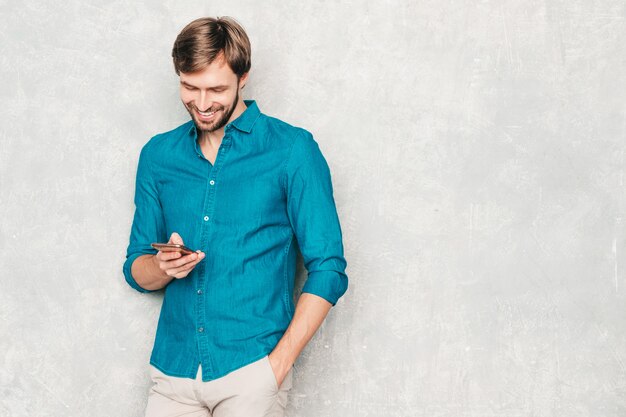 Modelo de hombre de negocios lumbersexual sonriente hermoso del inconformista que lleva la ropa casual de la camisa de los pantalones vaqueros