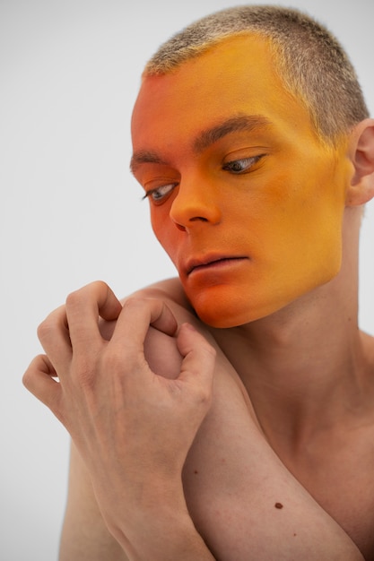 Modelo de hombre posando con pintura corporal colorida