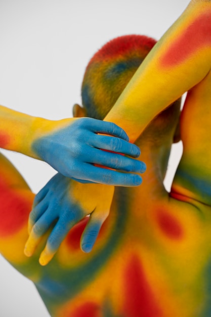 Modelo de hombre posando con pintura corporal colorida