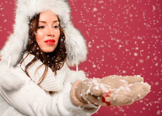 Modelo de invierno de moda cogiendo copos de nieve