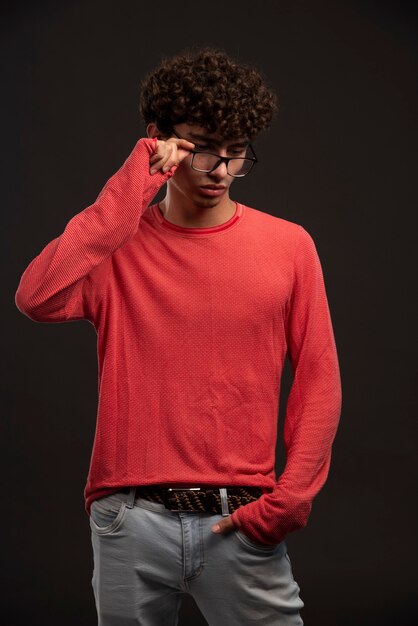 Modelo joven en camisa roja con anteojos.